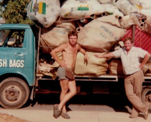 old picture of two males and dickies trees mulching backs on an old truck